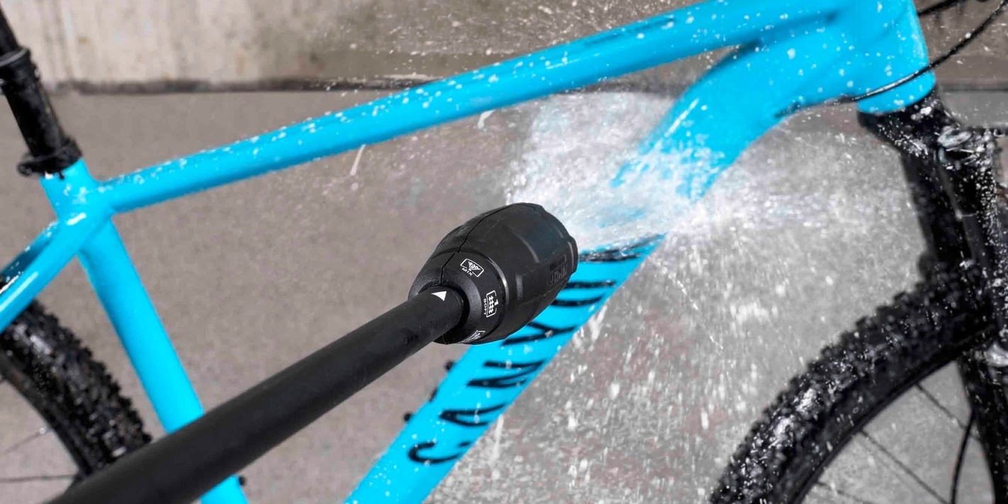 Schritt 2: Fahrrad mit Wasser reinigen ein hellblaues Fahrrad wird mit einem Kärcher Hochdruckreiniger gereinigt