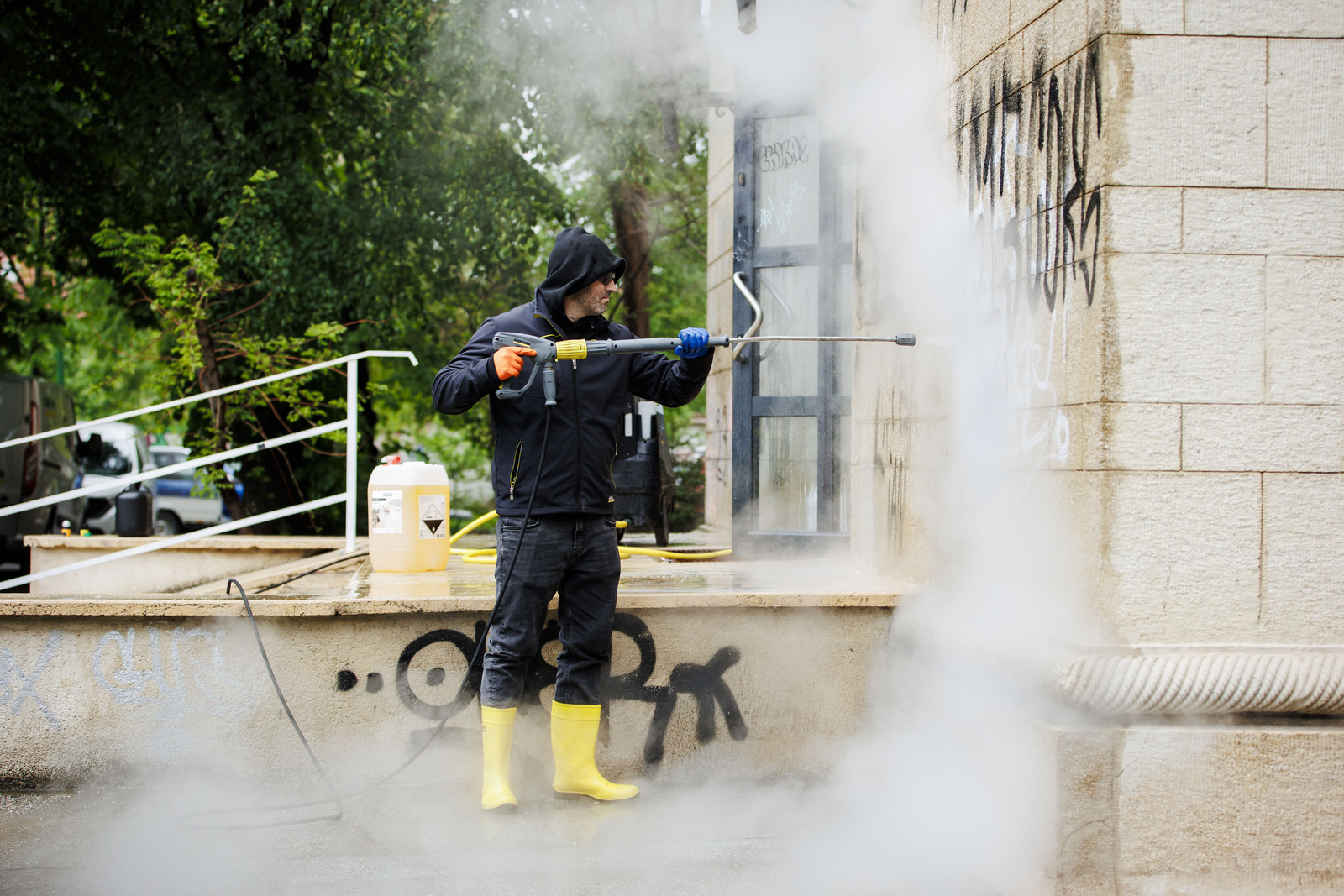 Ein Kärcher Mitarbeiter entfernt Graffiti von den Außenwänden Ein Kärcher Mitarbeiter entfernt Graffiti von den Außenwänden
